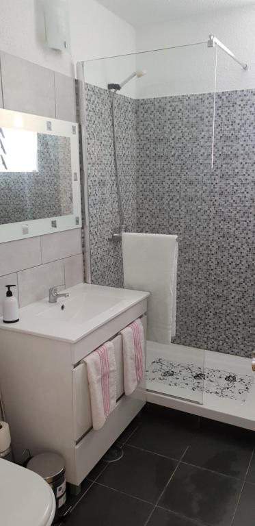 a white bathroom with a sink and a shower at Esthela home in Funchal