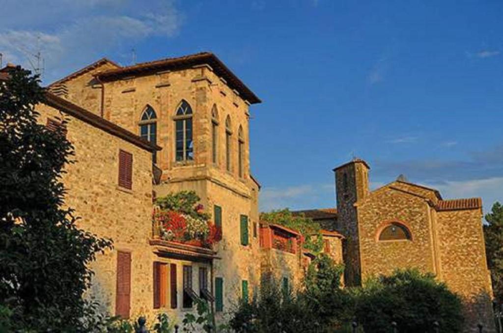 a large stone building with a window and a tower at La Torre di Pieve in Pieve Santo Stefano