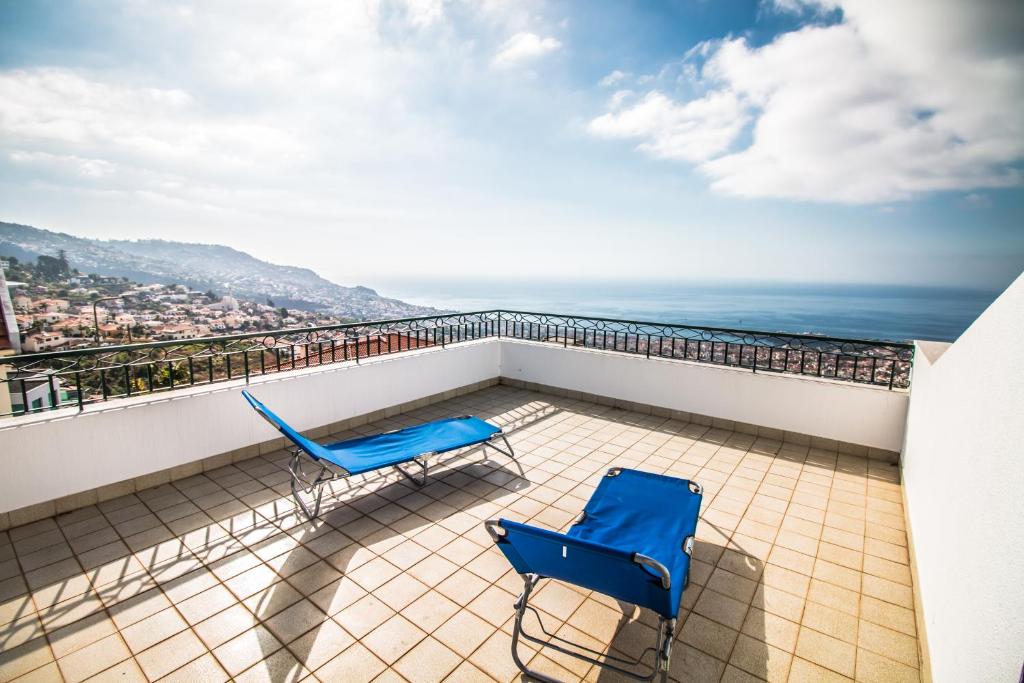 un balcón con 2 sillas azules y el océano en Monte Vista Hermosa, en Funchal