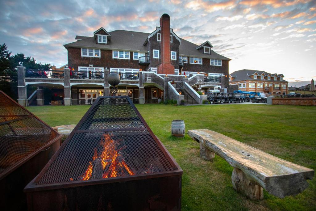 a large house with a fire grill and a bench at McMenamins Gearhart Hotel in Gearhart