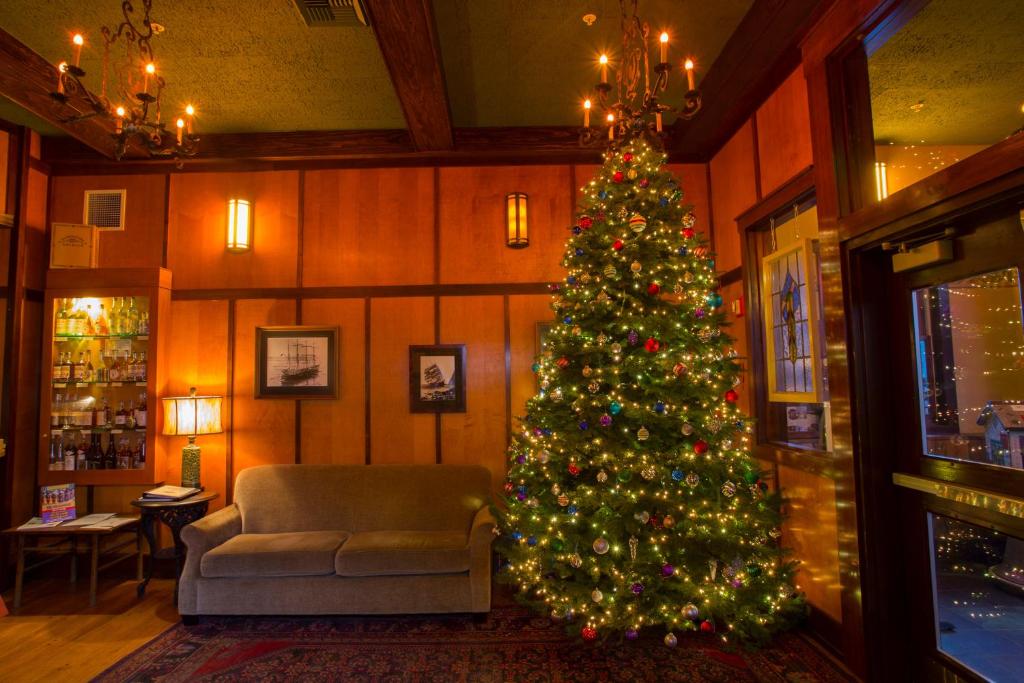 a christmas tree in a living room with a couch at McMenamins Gearhart Hotel in Gearhart