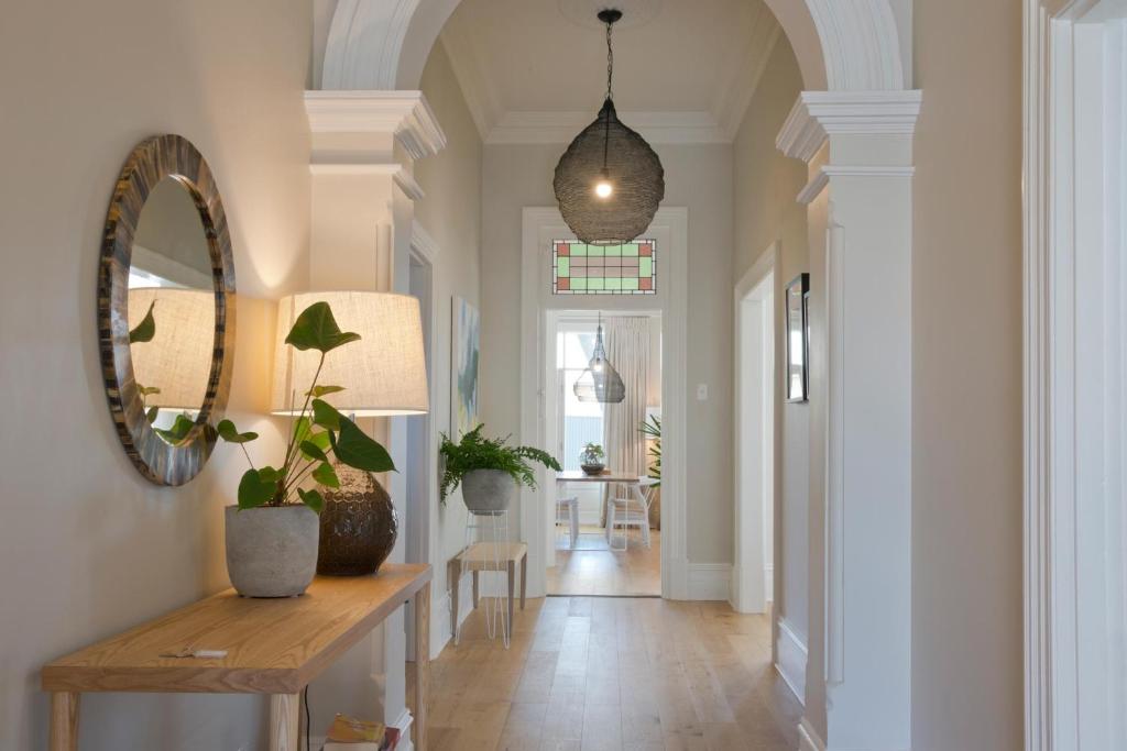 タナンダにあるVilla Maria Barossa Luxury Guesthouseの鏡と植物のテーブルが備わる廊下