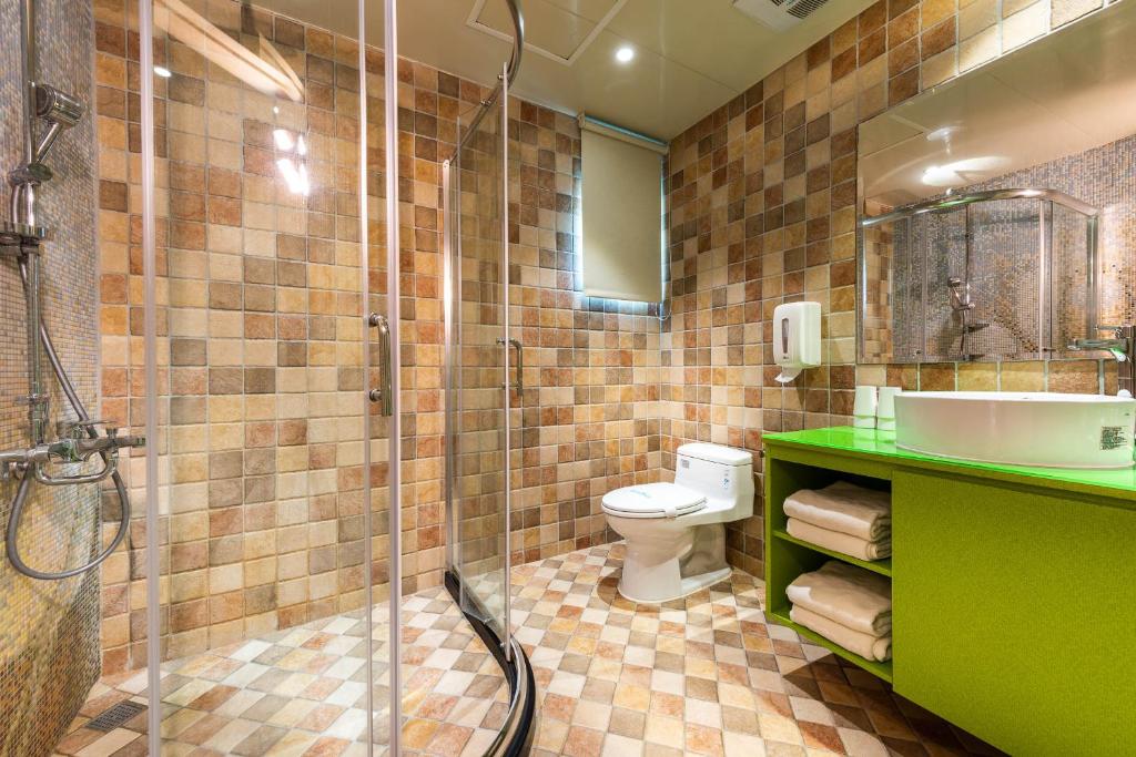 a bathroom with a shower and a toilet and a sink at Shichi Hotel in Kaohsiung