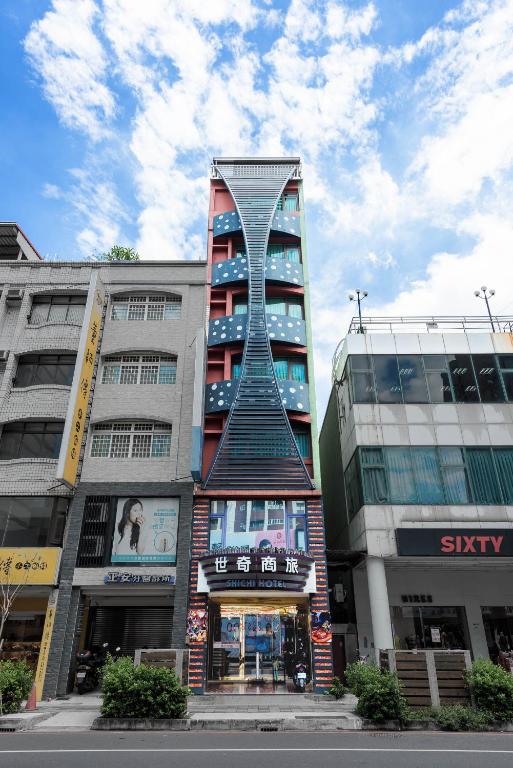 a tall building with a spiral tower in a city at Shichi Hotel in Kaohsiung