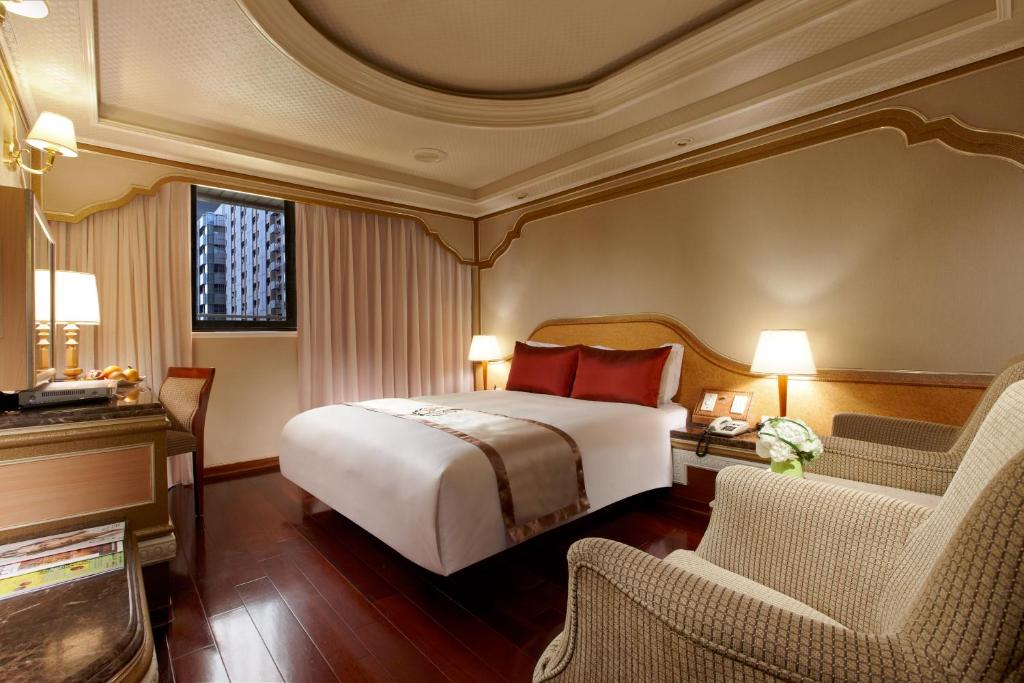 um quarto de hotel com uma cama e duas cadeiras em Tai Hope Hotel em Taipei