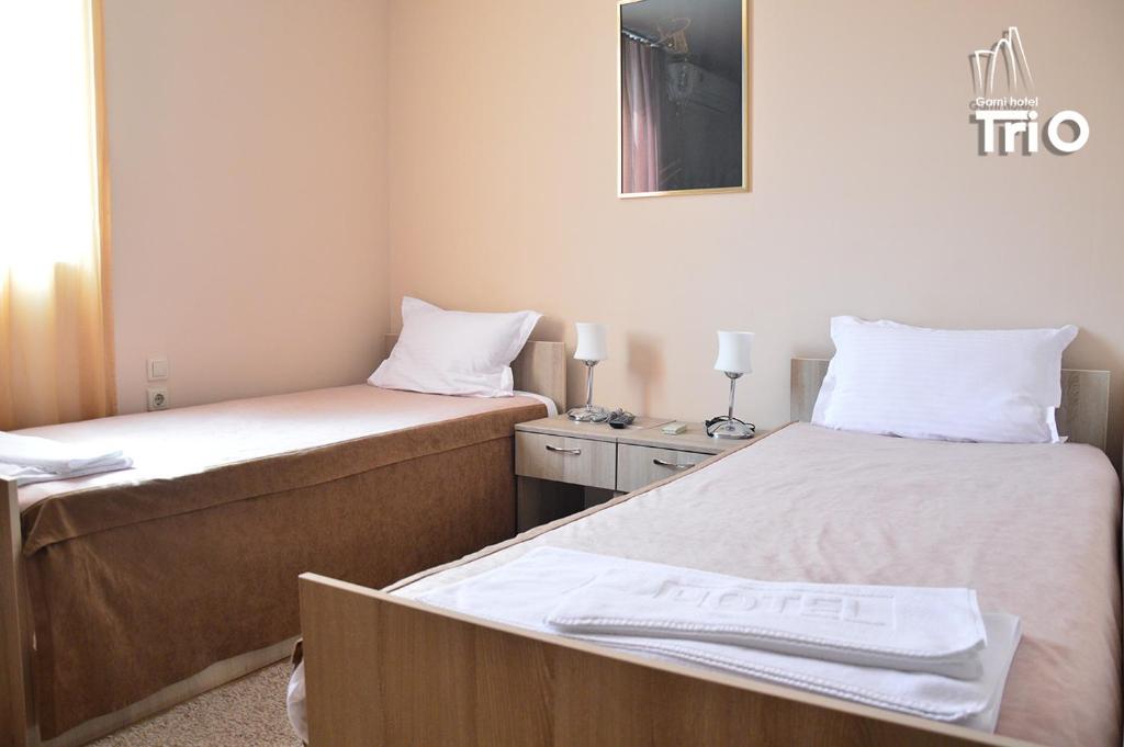 Postel nebo postele na pokoji v ubytování Garni Hotel Tri O