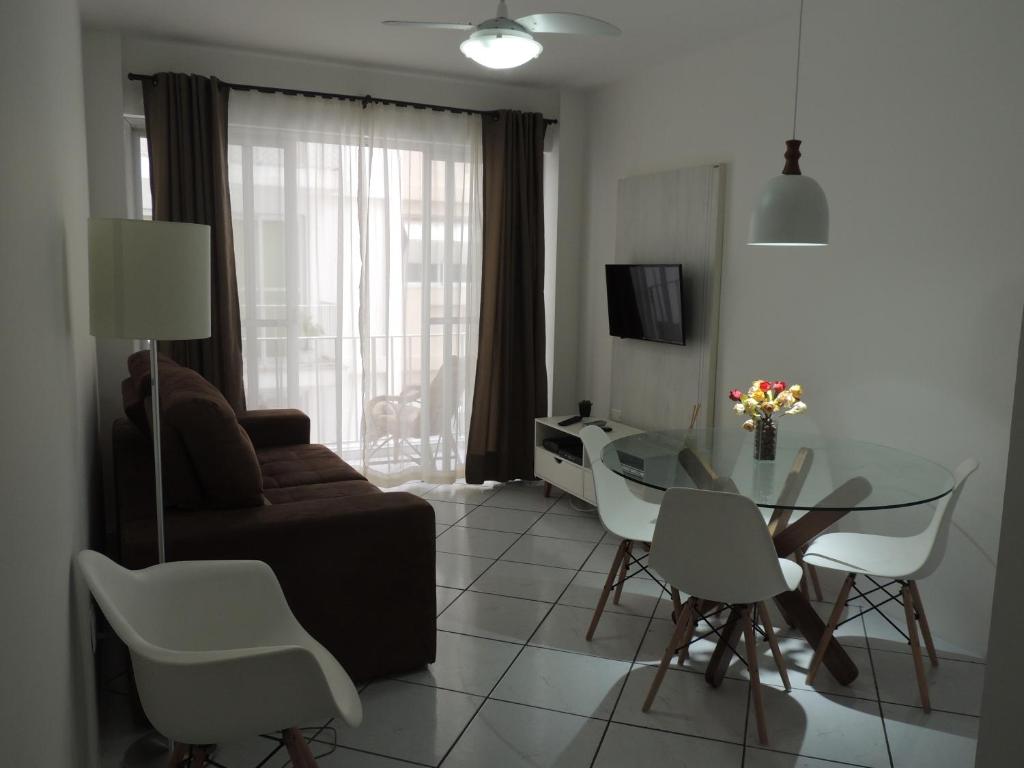 Apartamento Confortavel em Balneário Camboriu في باليريو كامبوريو: غرفة معيشة مع أريكة وطاولة وكراسي