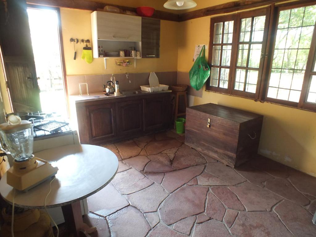 a kitchen with a counter and a table in a room at Chochis Cabañas in Chochis