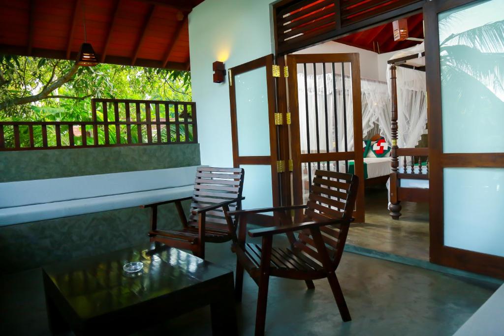 a room with two chairs and a table on a balcony at Goyambokka Guesthouse in Tangalle