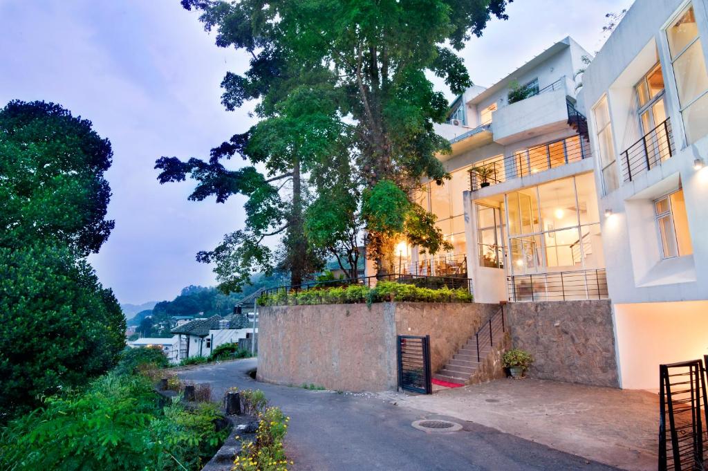 una casa con un albero sul lato di una strada di Hotel See Kandy a Kandy
