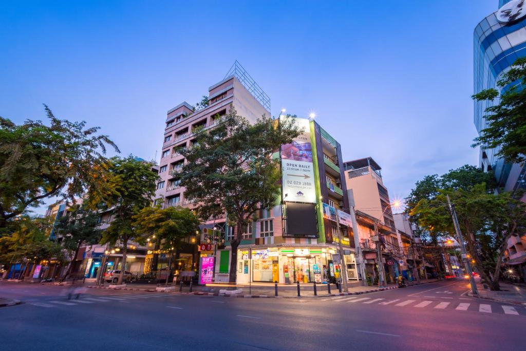 a city street with a tall building on a street at For You Residence in Bangkok