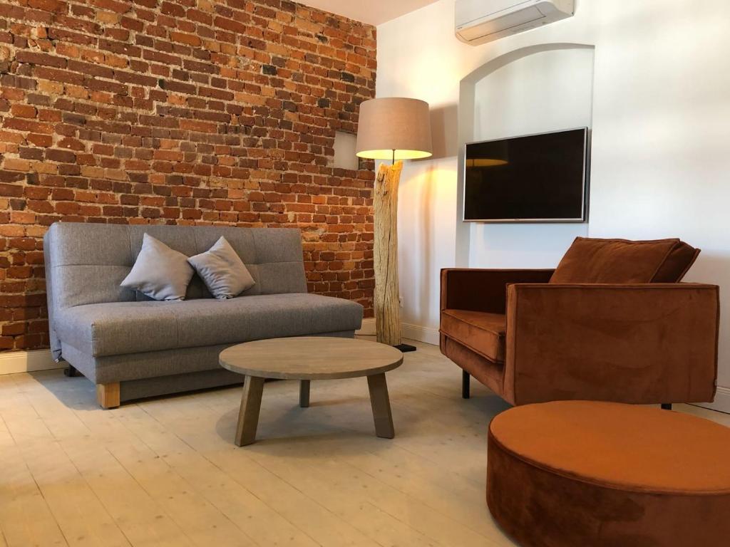 a living room with a couch and a chair at VIA`s Appartements und Ferienwohnungen in Görlitz