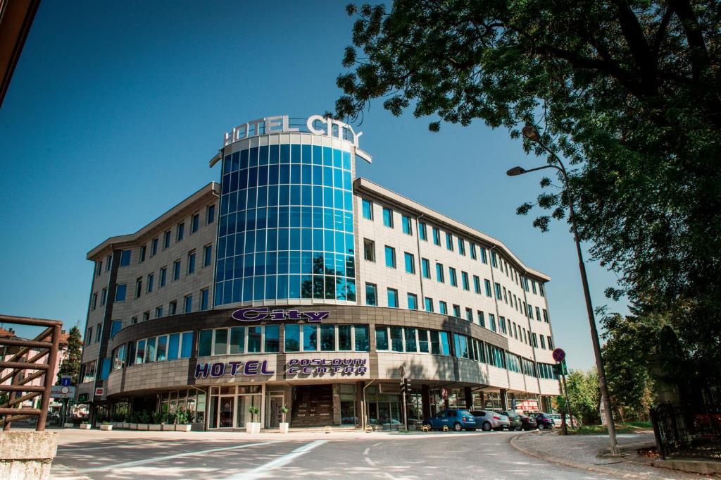 a large building with a clock on the front of it at Hotel CITY in Prnjavor