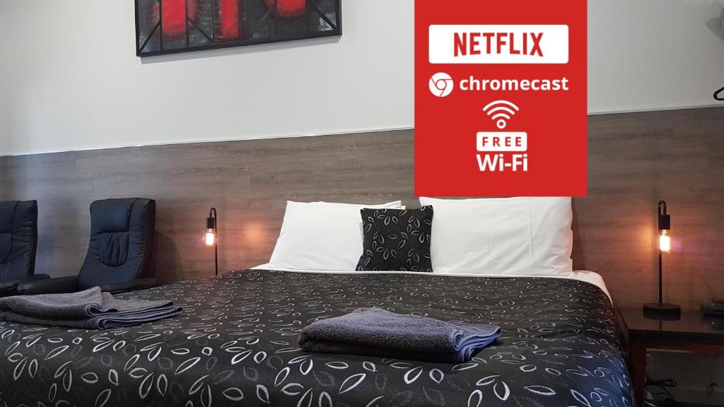 ein Schlafzimmer mit einem Bett mit einem Schild drauf in der Unterkunft Motel24Seven and Apartments in Sale