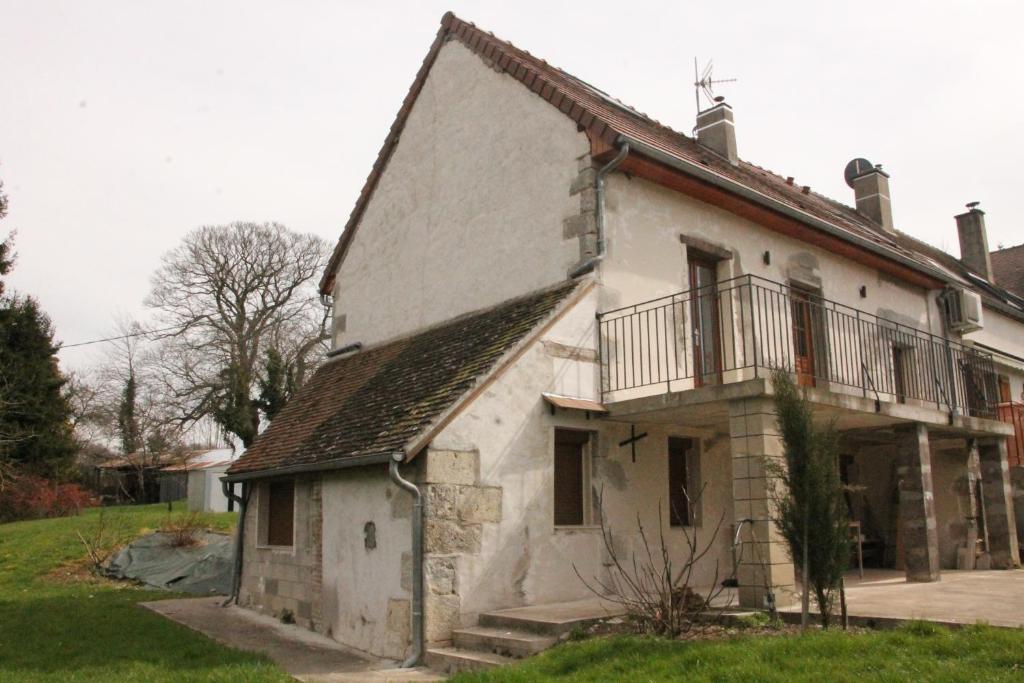 una casa antigua con un balcón en el lateral. en La maison de Maxou en Briare