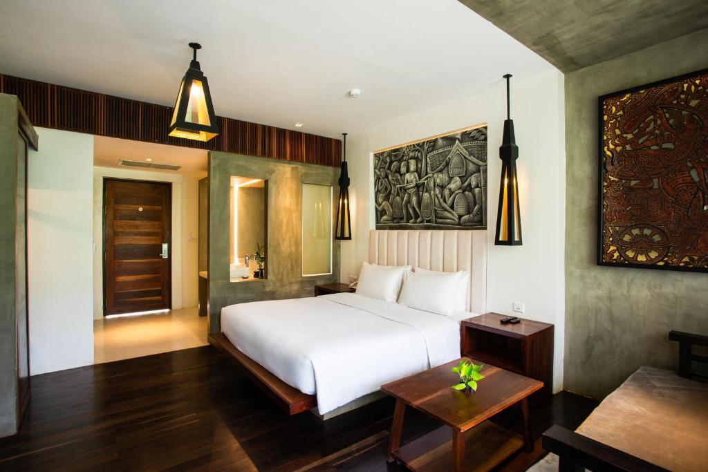 a bedroom with a white bed and a table at Apsara Residence Hotel in Siem Reap