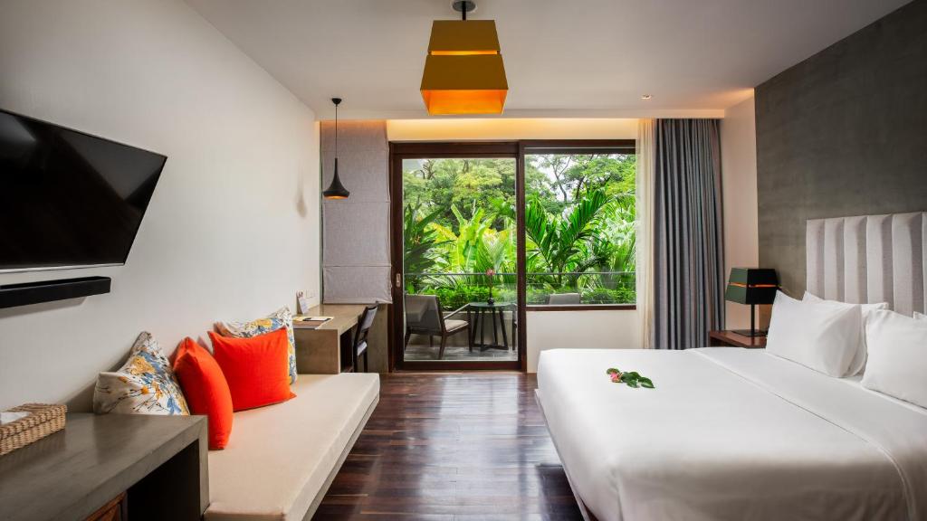 a hotel room with a bed and a couch at Apsara Residence Hotel in Siem Reap