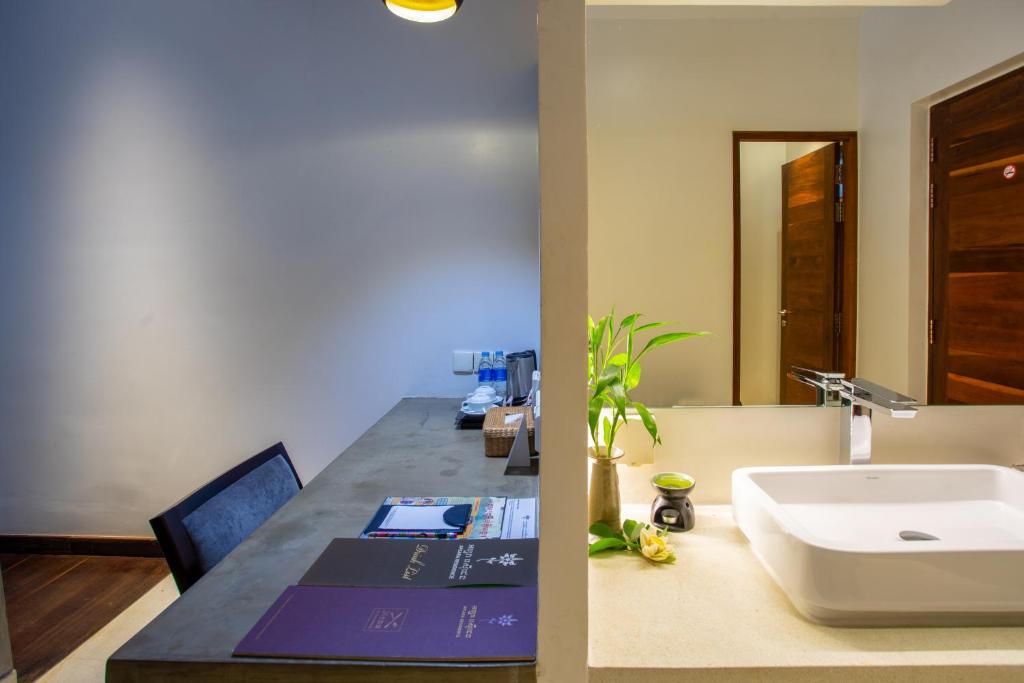 a bathroom with a sink and a desk with a sink at Apsara Residence Hotel in Siem Reap