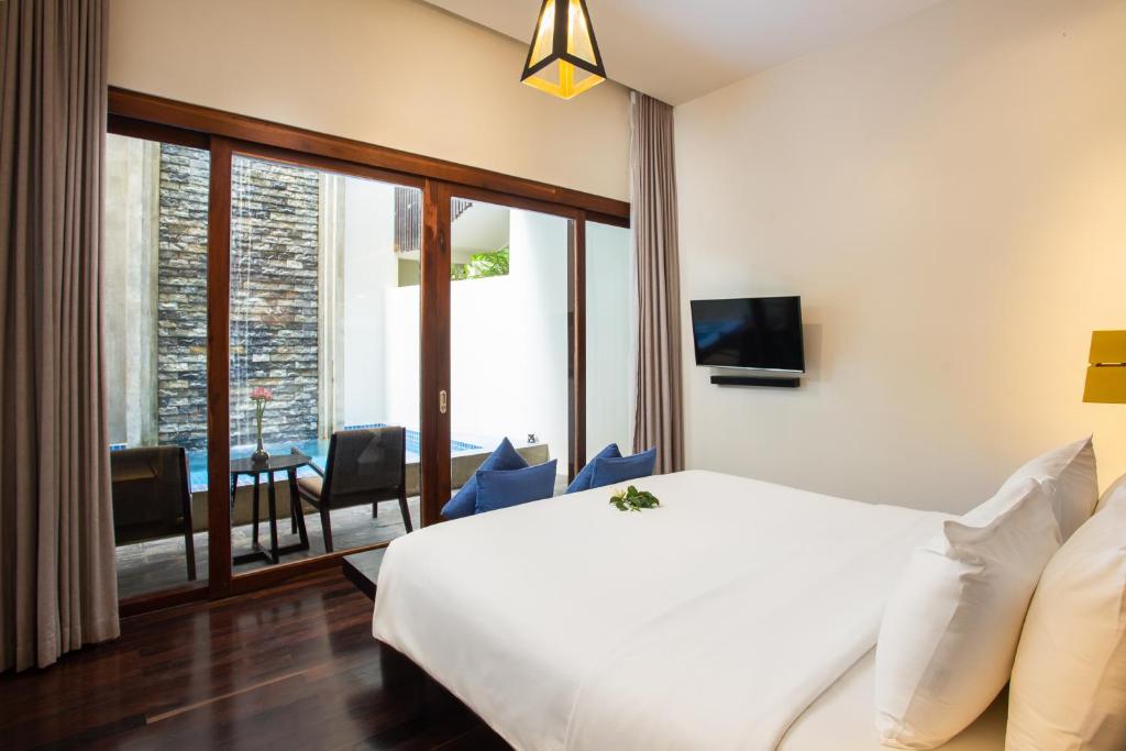 a hotel room with a white bed and a balcony at Apsara Residence Hotel in Siem Reap