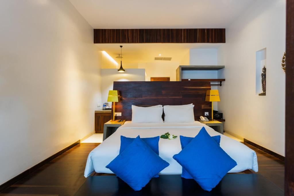 a bedroom with a large bed with blue pillows at Apsara Residence Hotel in Siem Reap