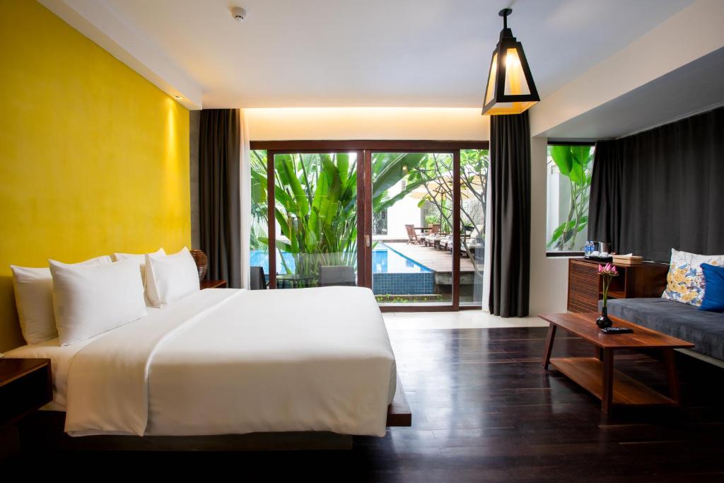a bedroom with a large white bed and a couch at Apsara Residence Hotel in Siem Reap