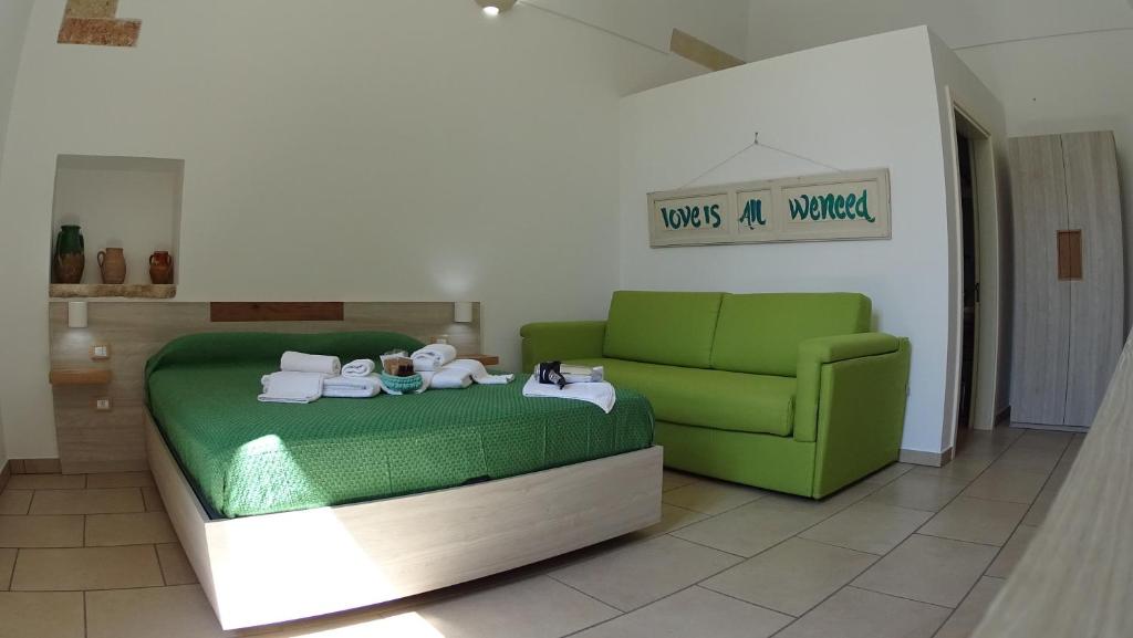 a living room with a green couch and a green couch at Manipinta B&B in Corigliano dʼOtranto