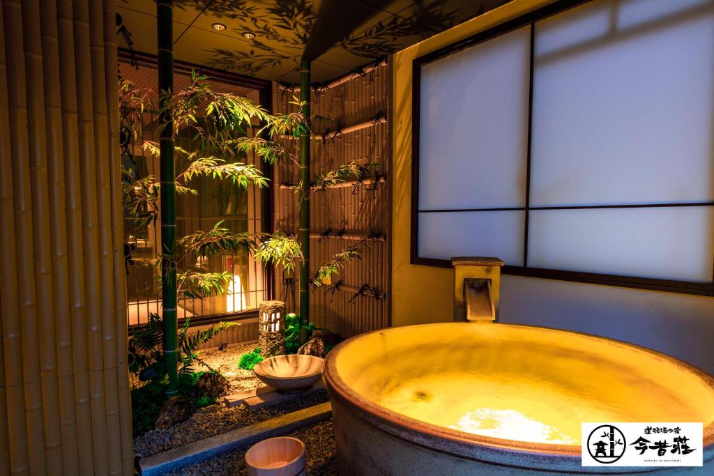 a bath tub in a bathroom with a window at Konjaku-So Dotonbori Garden SPA Stay in Osaka