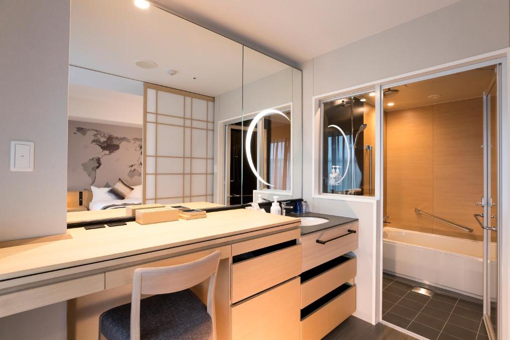 a bathroom with a desk and a sink and a tub at Centrair Hotel in Tokoname
