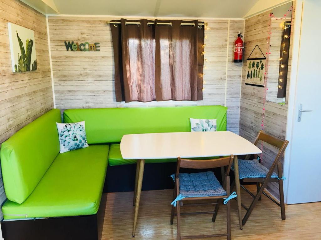 - un canapé vert et une table dans la chambre dans l'établissement Tropical Bungalow 1, à Vic-la-Gardiole