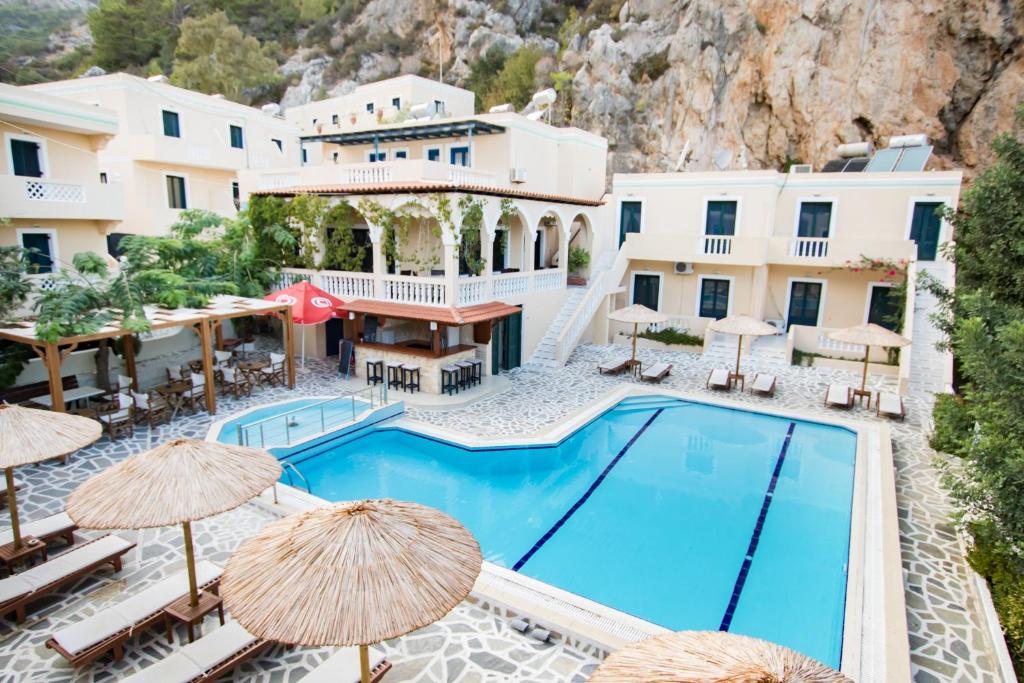 a view of the pool at a hotel with umbrellas at Kyra Panagia Hotel in Kyra Panagia