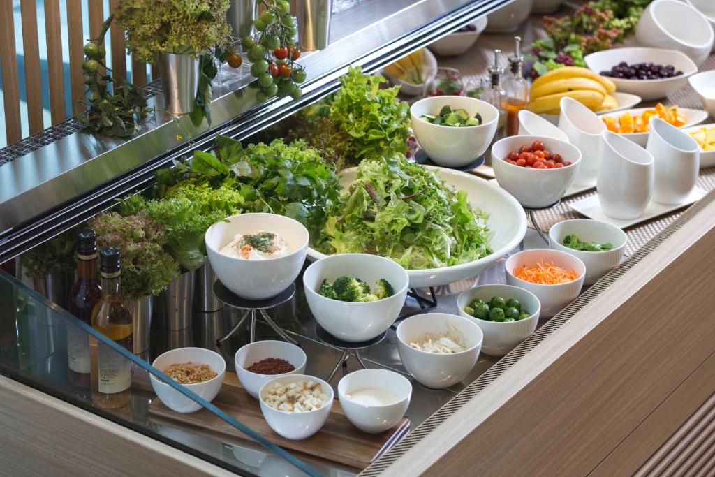 a buffet line with bowls of vegetables and other foods at Centrair Hotel in Tokoname