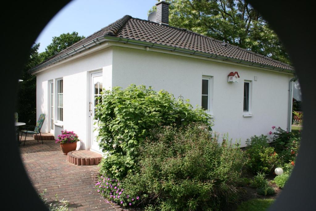 una casa blanca con una pasarela de ladrillo delante de ella en Ferienhaus Nachtigall, en Rechlin