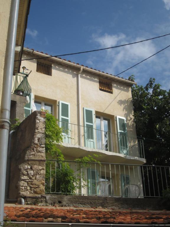 un edificio con persianas verdes y balcón en 28 Rue de la Ferrage, en Fayence