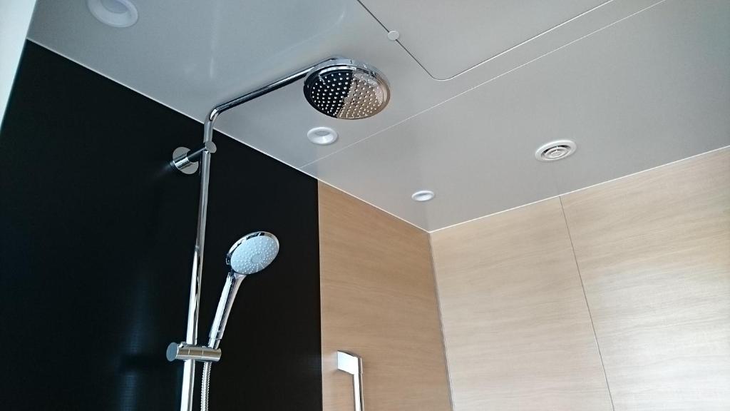 a room with a shower with a microphone on the ceiling at Centrair Hotel in Tokoname