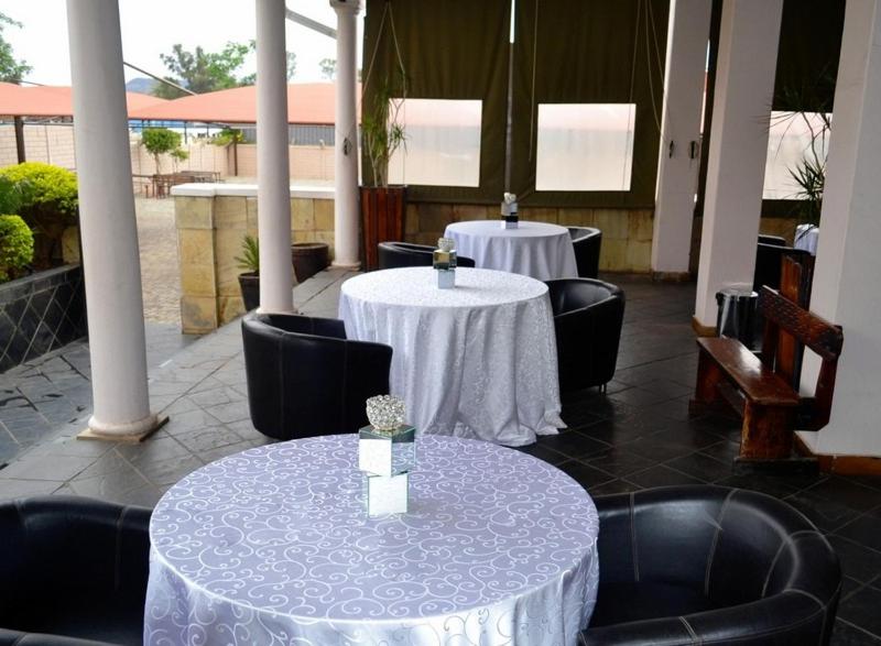 dos mesas con manteles blancos en un restaurante en Crown Hotel, en Ladysmith