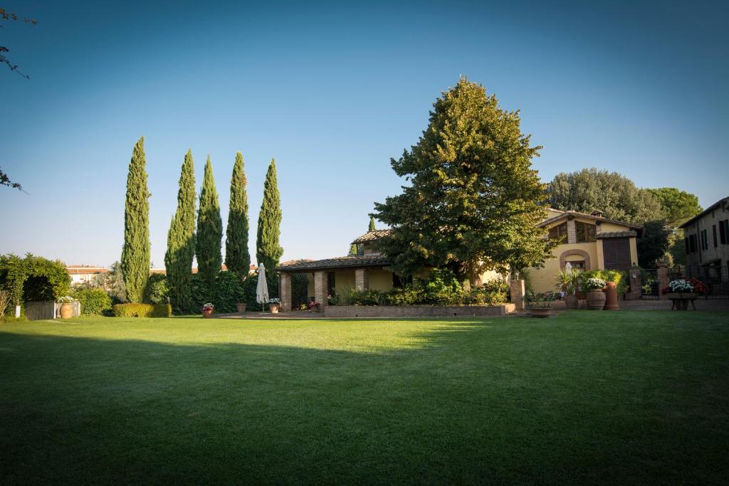 un gran patio con una casa y árboles en Borgo Villa Risi, en Siena