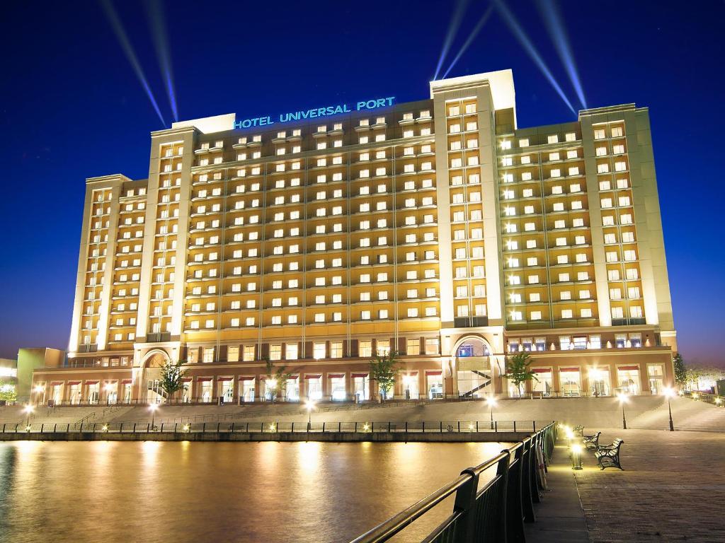 un grand bâtiment d'hôtel avec une rivière en face dans l'établissement Hotel Universal Port, à Osaka