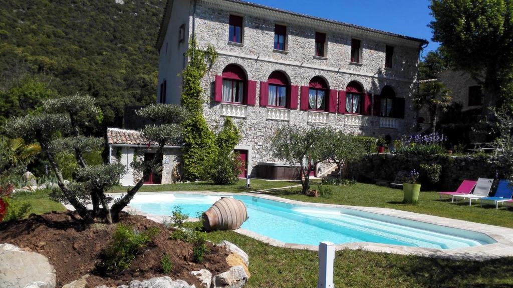 a house with a swimming pool in front of a building at Domaine de Rochebelle in La Cadière