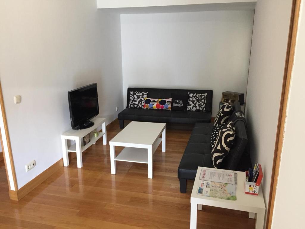 a living room with a couch and a table at FELIPEIV,centrico,terraza,wifi,parking 20 euros night in San Sebastián