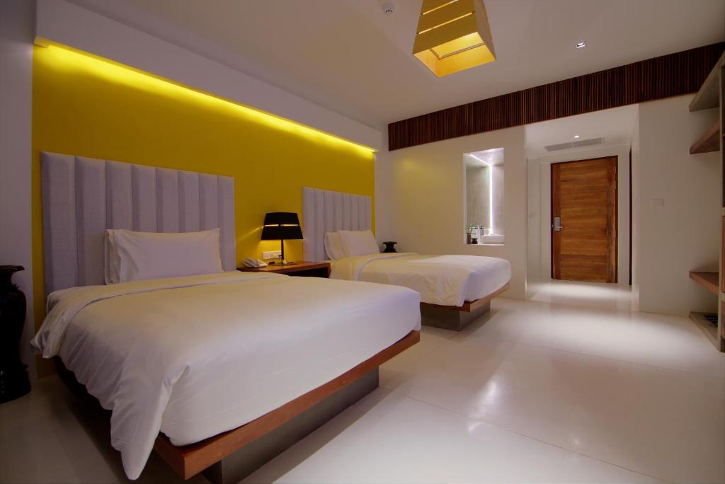 a bedroom with two beds and a yellow wall at Apsara Residence Hotel in Siem Reap