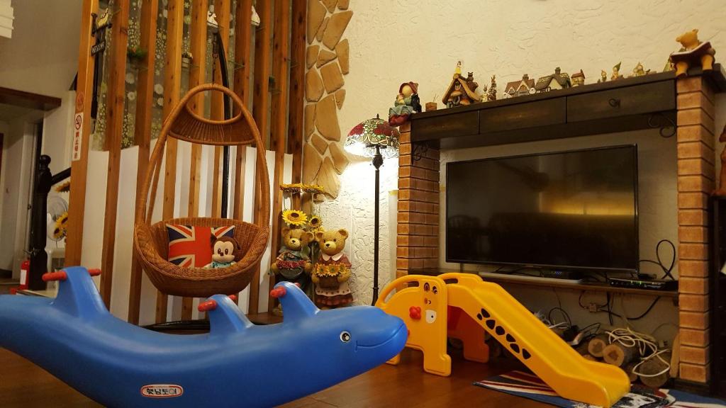 a living room with a toy dolphin and a tv at British Country Inn B&amp;B in Luodong