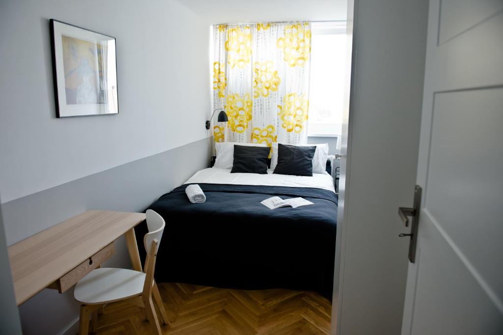 a small bedroom with a bed and a desk and a window at Apartament Chłodna near to city center in Warsaw