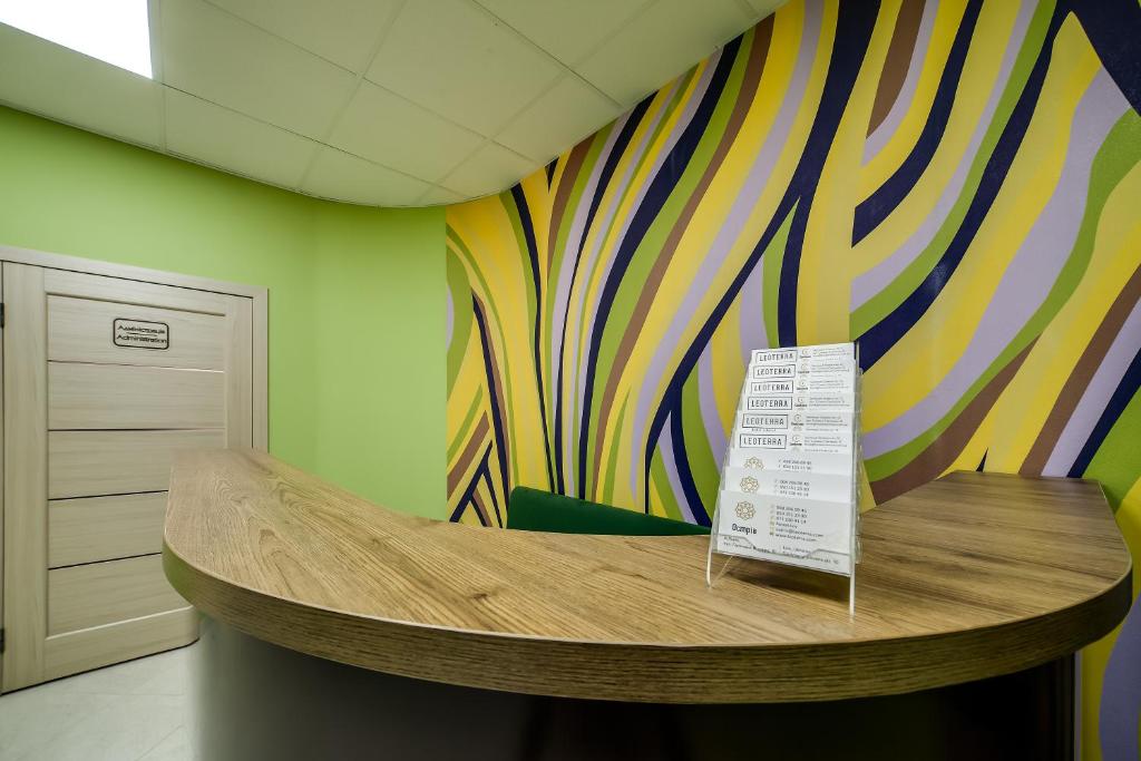 a room with a table with a colorful wall at Ostriv Hostel in Lviv