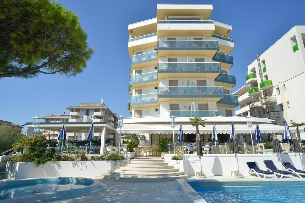 un hotel con piscina frente a un edificio en Hotel Anthony, en Lido di Jesolo