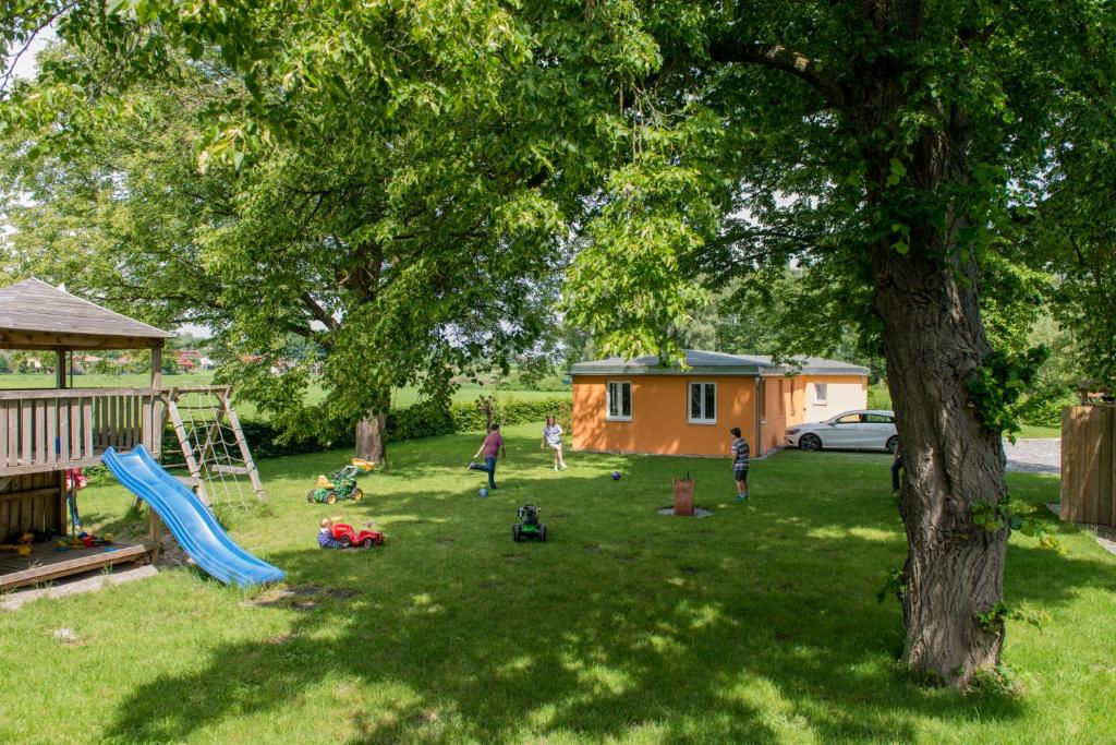 a group of children playing in a yard with a tree at An der Günz in Waldstetten