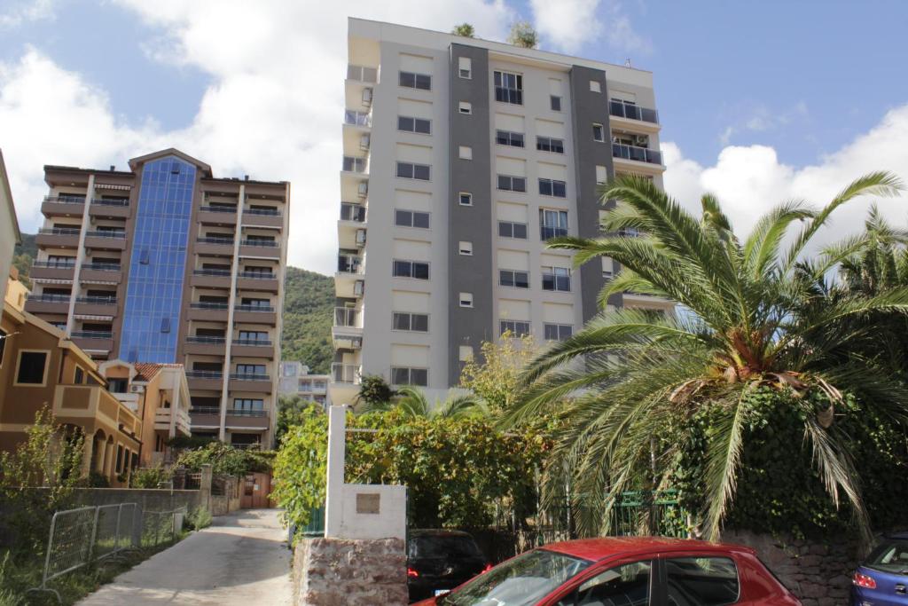 une voiture garée devant un grand bâtiment dans l'établissement Olimp Lux II, à Budva