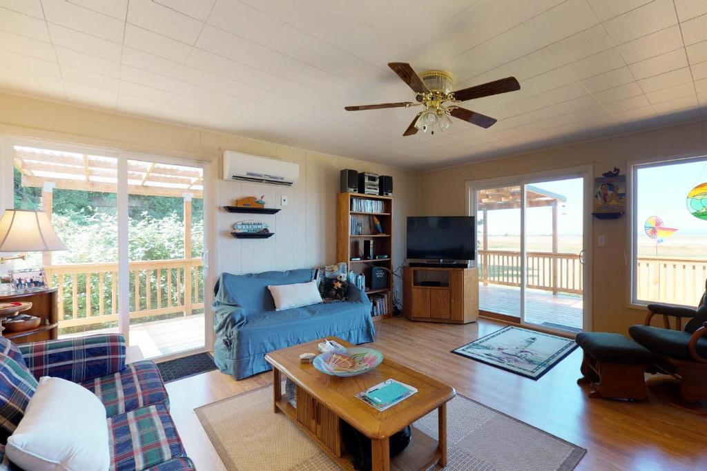 a living room with a blue couch and a ceiling fan at Surfer's Â Landing in Westport