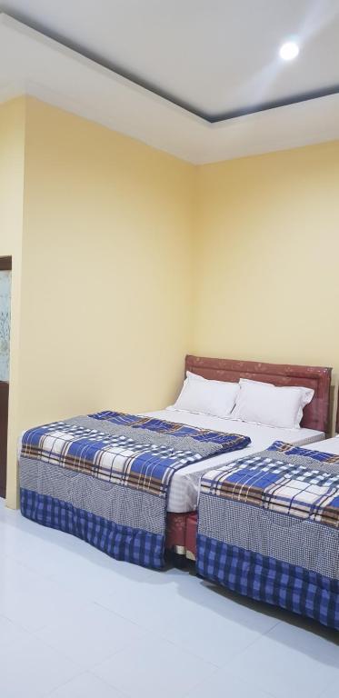 two beds sitting next to each other in a bedroom at Vila tenjo gunung in Cilowa