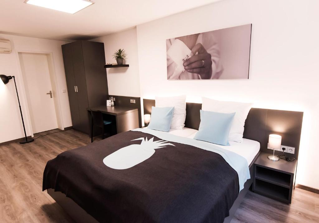 een hotelkamer met een bed met een zwart-witte deken bij Mood contemporary living in Mannheim