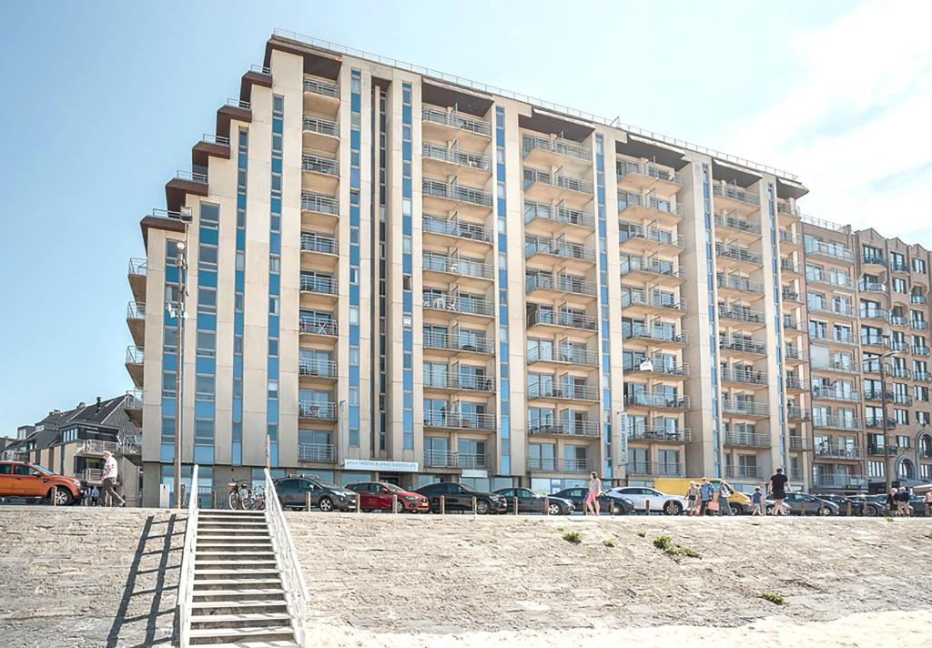 a large building on the beach in front of a building at Holiday Suites Blankenberge in Blankenberge